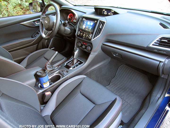 2017 Subaru Impreza Sport passenger side dash, gloss black shift surround, heated seat buttons, and passenger seat with black sport cloth interior with red stitching. Optional rubber floor mats.