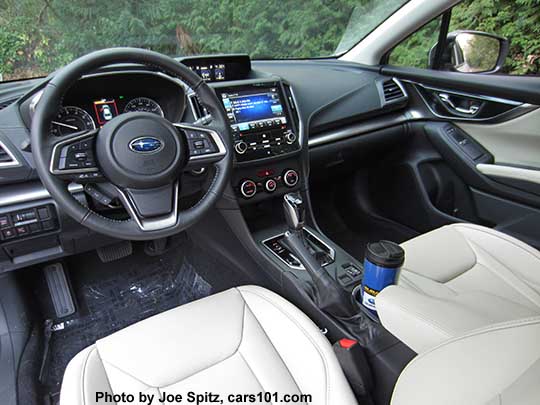 2017 Subaru Impreza Limited leather front seats, CVT gloss black shift knob and surround, 8" audio,  silver trimmed automatic climate control knobs, heated seat buttons, two fixed cupholders (with blue travel mug shown). ivory leather shown.