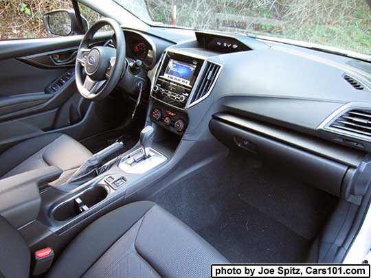 2017 Subaru Impreza Premium passenger side dash, and passenger seat with black cloth interior, and silver shift surround. heated seat buttons