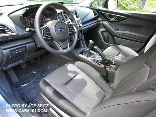 from driver's side 2017 Subaru Impreza 2.0i base model interior, dash and steering wheel, manual transmission shown