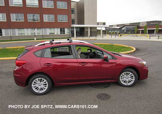 side view 2017 Subaru Impreza Premium 5 door hatchback, 16" silver alloys, silver roof rack rails with optional aero cross bars Venetian Red car shown