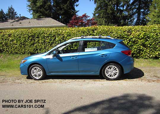 side view 2017 Subaru Impreza 5 door hatchback. Island blue pearl color. with 16" silver alloys, silver roof rack rails, body color door handles and mirrors. Optional roof rack aero crossbars.