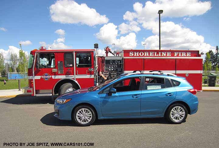 2017 Subaru Impreza Island blue pearl  5 door hatchback next to Shoreline's finest's firetruck, Fire Engine Red color shown.