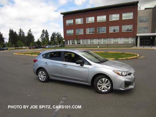 2017 Subaru Impreza 2.0i base model 5 door hatchback, ice silver shown. Steel wheels with covers, unpainted mirrors, no roof rails.