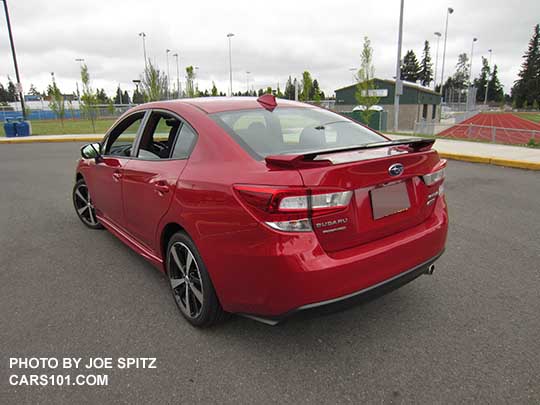 rear view 2017 Subaru Impreza Sport 4 door sedan, 18" alloys, black rear spoiler with body colored uprights. lithium red pearl shown.