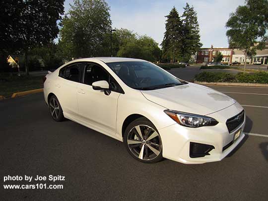 2017 Subaru Impreza Sport 4 door sedan with machined 18" alloys, body colored mirrors with turn signals. Crystal white shown.