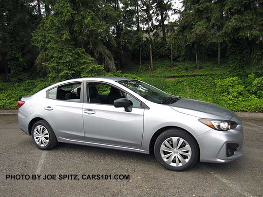 side view 2017 Subaru Impreza 2.0i 4 door sedan, with black outside mirrors, 16" wheels with plastic wheel covers. Ice silver shown.