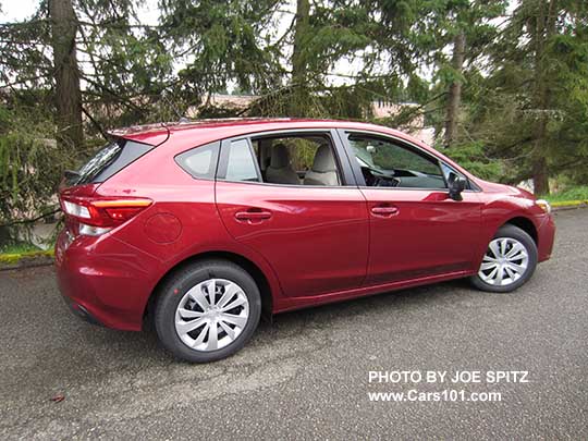 side view 2107 Subaru Impreza 2.0i base model 5 door hatchback, venetian red color.  Steel wheels with plastic wheel covers.