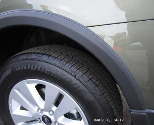 closeup of the optional wheel arch moldings, wilderness green 2015 Outback shown