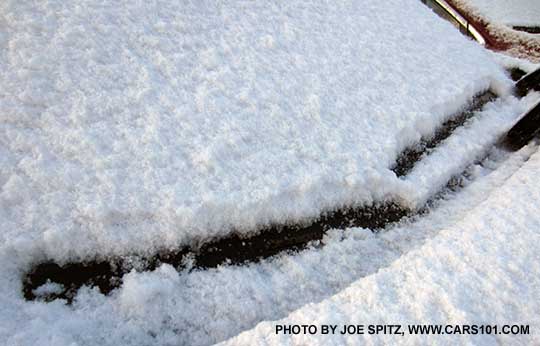 2015 Subaru outback front windshield wiper de-icers shown with snow. They heat the lower front of the windshield