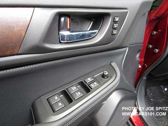 closeup of the woodgrain trim, chrome inner door handle, perforated gray leatherette, power window/lock buttons with matte gray trim on the 2017 Outback Limited driver's door panel