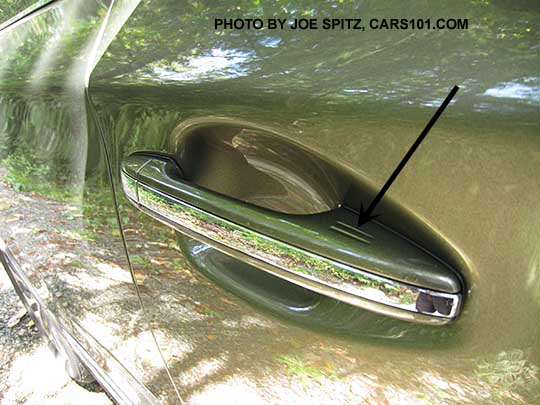 2017 Subaru Outback Touring outside door handles have chrome center accent strip. The black arrow points to the keyless access lock hotspot (rub to lock all doors). Wilderness green Touring shown.