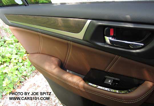 2017 Subaru Outback Touring rear door inner panel. Java brown ivory stitched leatherette, gloss black power window trim, silver tipped power window switch, matte woodgrain and metallic door trim, chrome inner door handle,