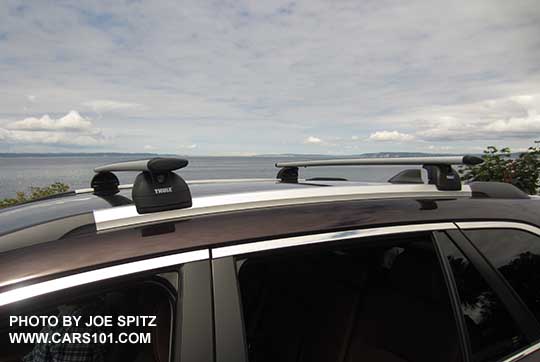 2017 brilliant brown Subaru Outback Touring low profile roof rails, silver with black ends, shown with optional Thule cross bars (Thule 460 system). Brilliant brown color shown.
