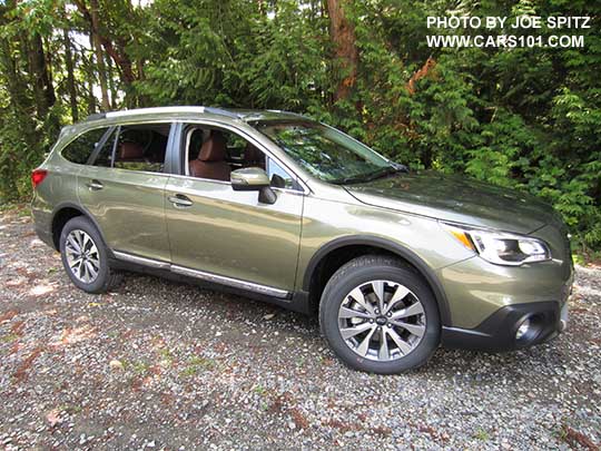 side view 2017 Subaru Outback Touring. Wilderness green shown. Silver Low profile roof rails, chrome trim, 18" silver and gray machined alloys, shown with optional wheel arch moldings