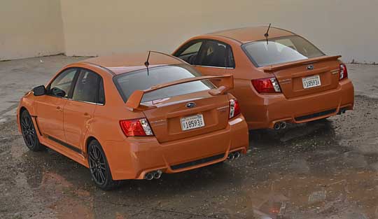 rear view 2013 subaru wrx and sti tangerine orange sedans.