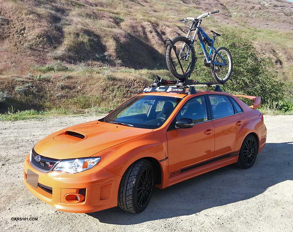 2013 special edition tangerine orange sti with subaru cross bars, and a bike