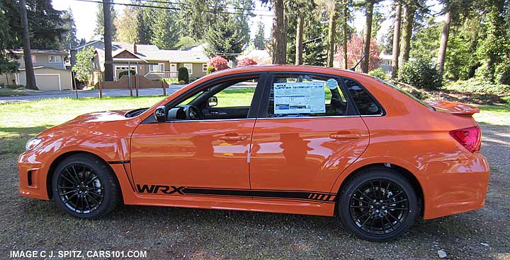 side view of limited production 2013 tangerine orange wrx special edition sedan with black striping, black alloys and