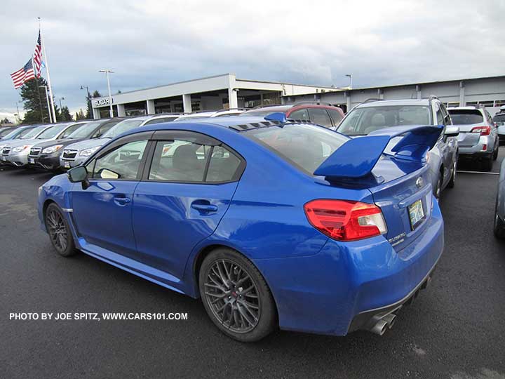 Optional side window deflectors and rear vortex generator on the roof by the antenna. 2015 WR Blue Subaru STI shown.