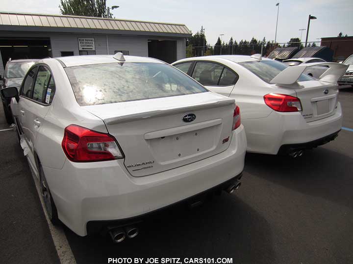 two white 2016 WRX STIs side-by-side.  Limited with small trunk lip spoiler and STI with wing spoiler