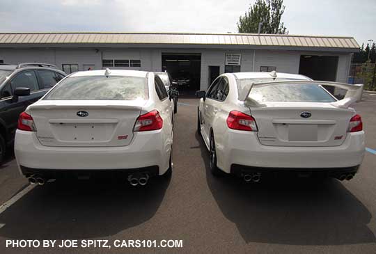 two white 2016 WRX STIs side-by-side.  Limited with small trunk lip spoiler (left) and STI with wing spoiler (right)
