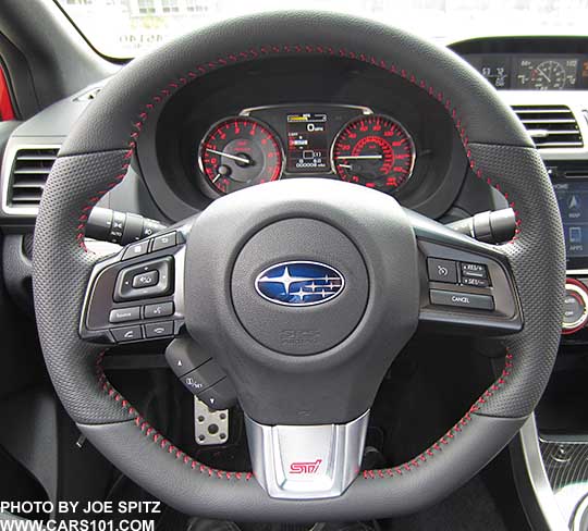 2017 Subaru STI D-shaped, flat bottom steering wheel is leather wrapped with red stitching, pebbled leather hand grips, and red STI logo on the middle spoke