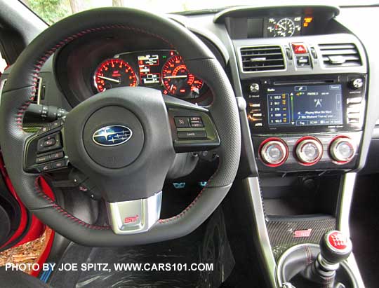 2017 Subaru STI  D-shaped, flat bottom steering wheel is leather wrapped with red stitching, pebbled leather hand grips, and red STI logo on the silver middle spoke