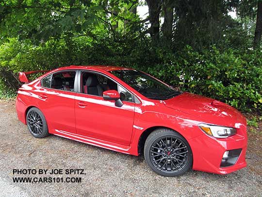 side view 2017 Subaru STI with fog lights, black alloys, wing spoiler. Pure red color