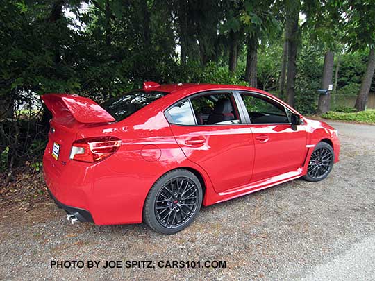 rear view 2017 WRX STI with tall wing spoiler, black 18" alloys. Pure red color shown.