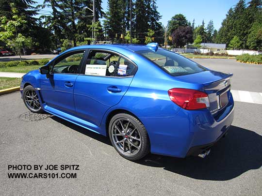 rear corner view WR Blue 2017 WRX STI Limited with silver 18" BBS alloys, small rear trunk lip spoiler