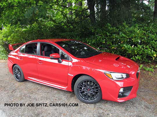 2017 Subaru STI with tall wing spoiler, black alloys. Pure red color