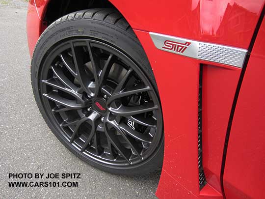 2017 Subaru STI fender logo and 18" alloy wheel on a Pure red car